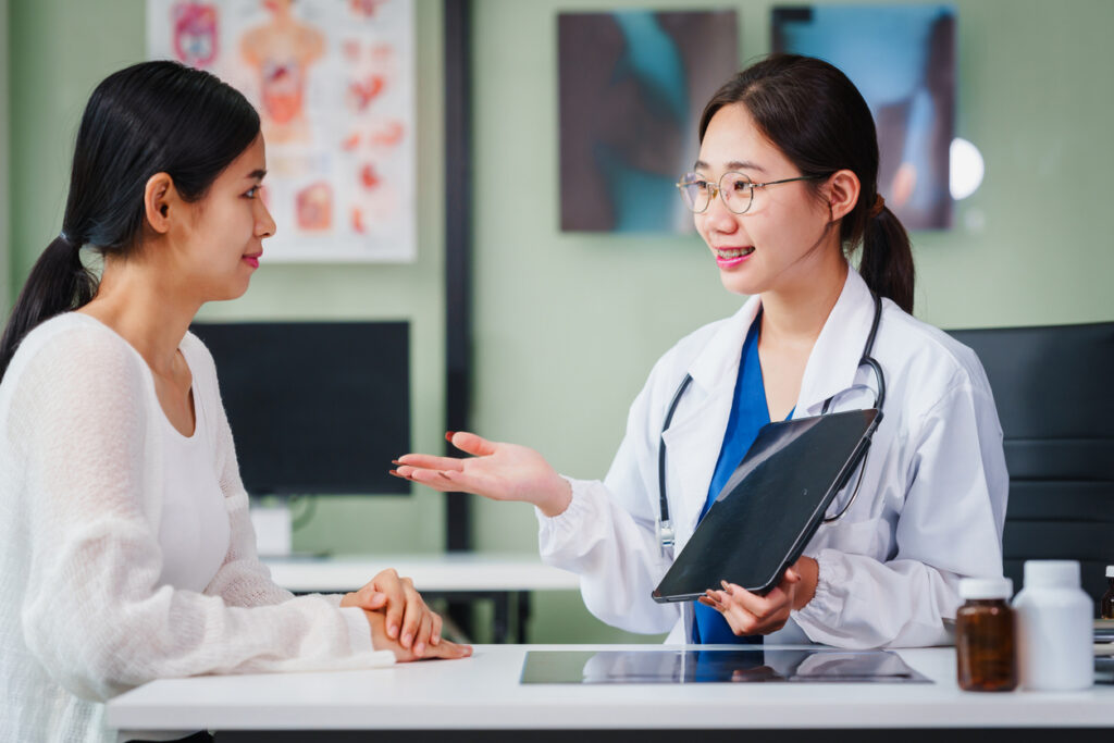 A mental health therapist in a clinical setting discussing ERP and CBT treatment options with a patient.