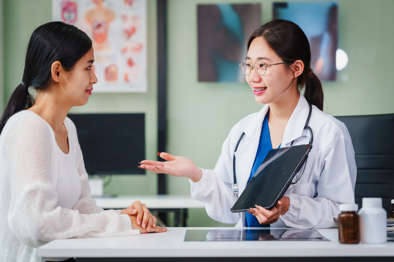 A mental health therapist in a clinical setting discussing ERP and CBT treatment options with a patient.
