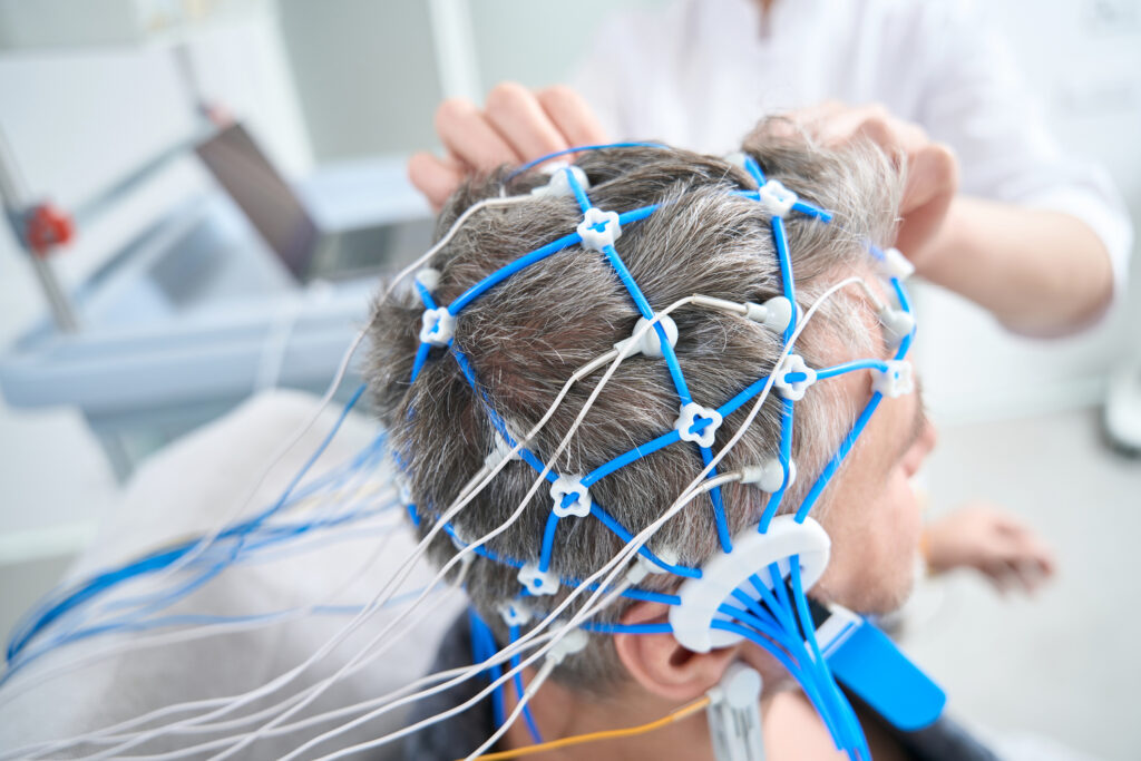 A medical professional administering clinical TMS therapy to a patient in a safe, controlled outpatient environment